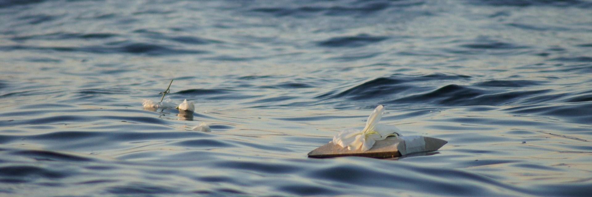 Erinnerungsgegenstände auf der Wasseroberfläche zur Seebestattung
